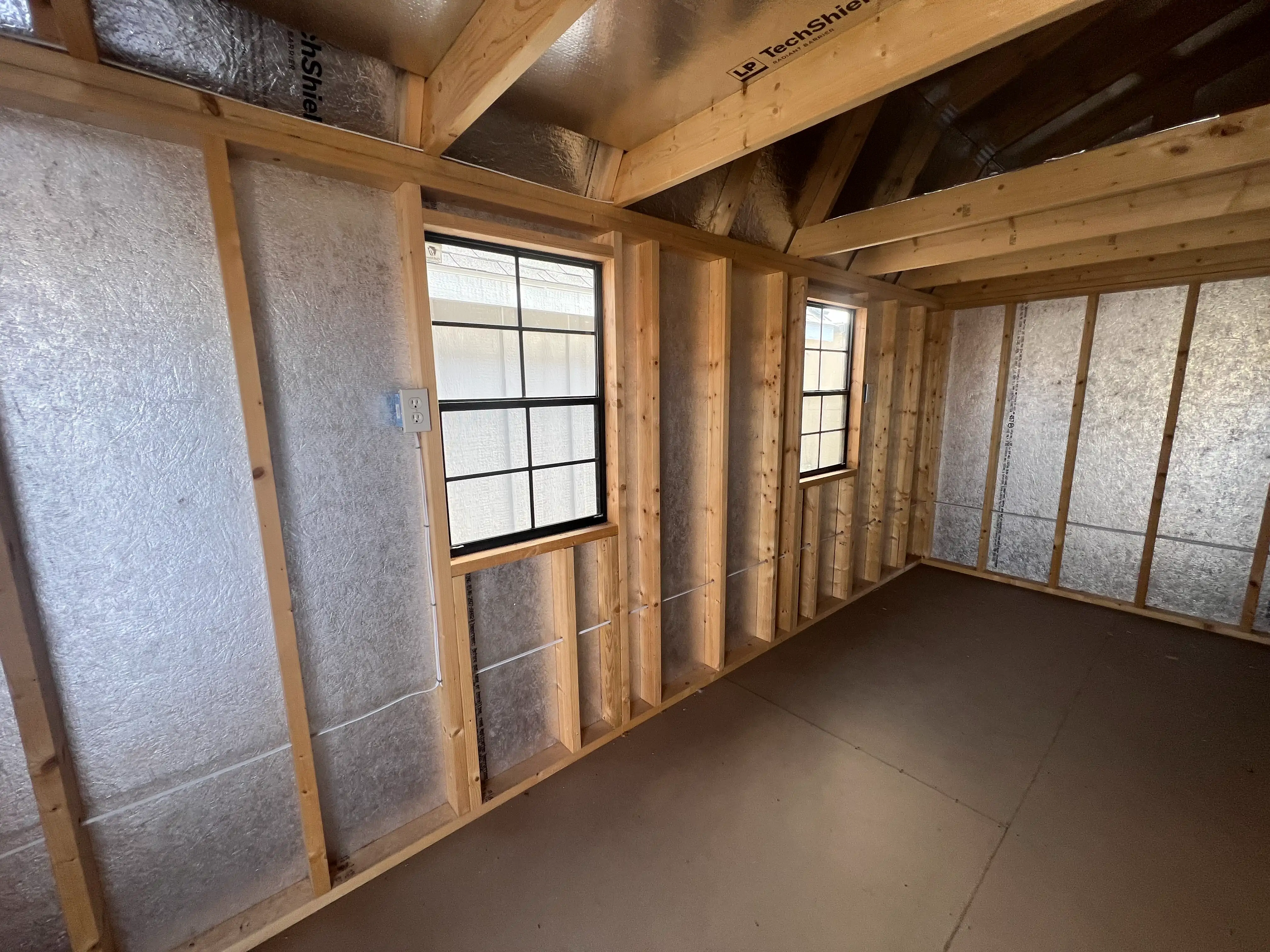 Illustration of heat reflection by a radiant barrier in a shed roof.